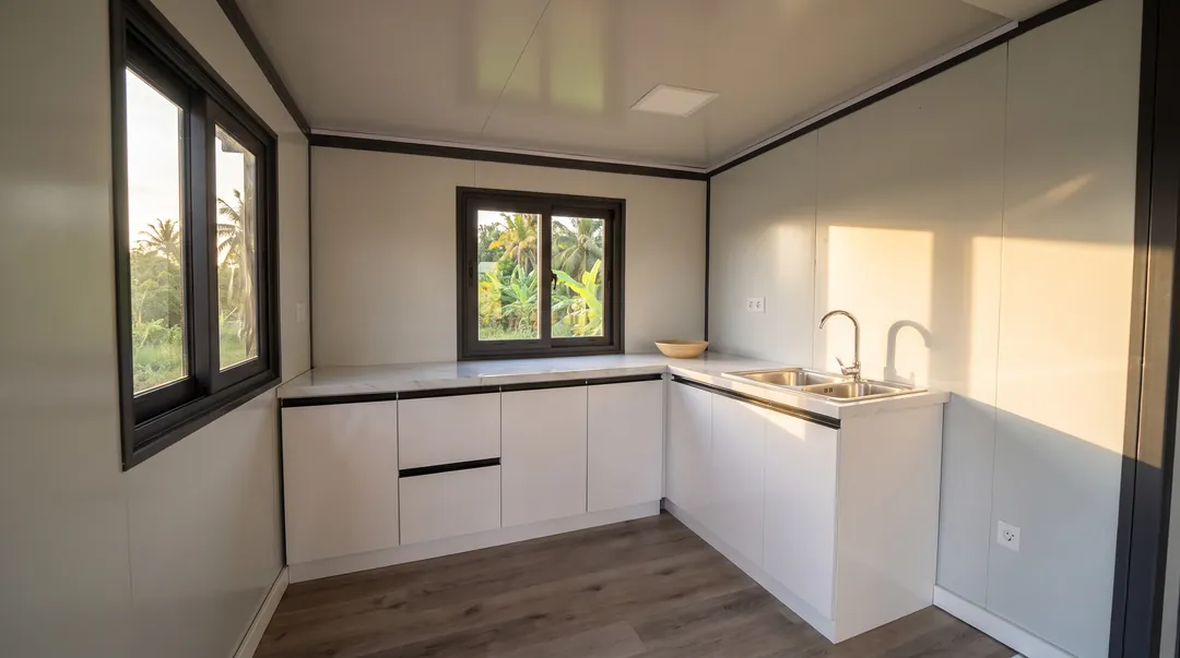 Cuisine en L blanche avec évier double bac et fenêtre au-dessus du plan de travail